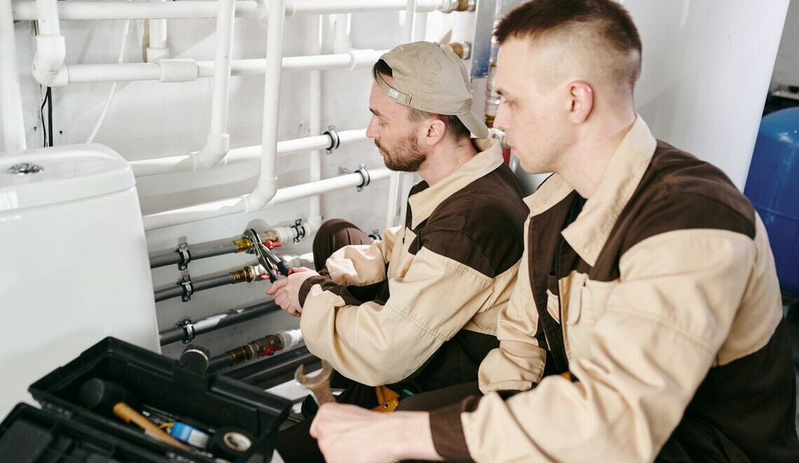two plumbers repairing pipes