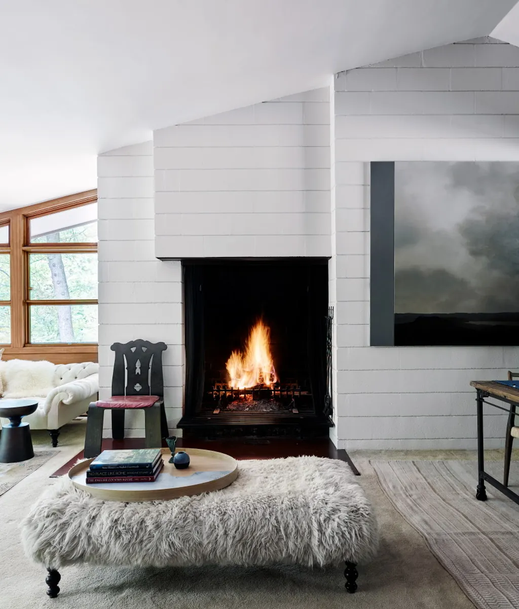 studio magness sitting area with white brick fireplace and shearling ottoman