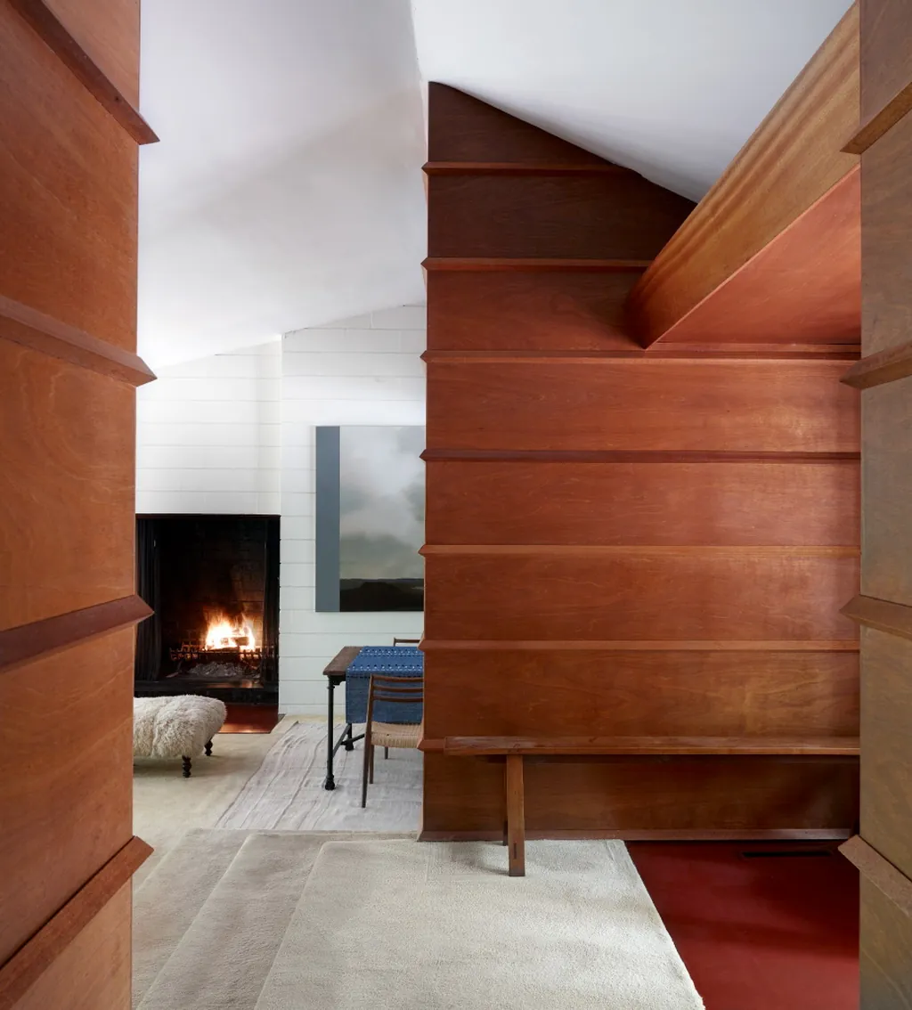 wood paneled hallway with built-in bench opening to a fireside dining nook