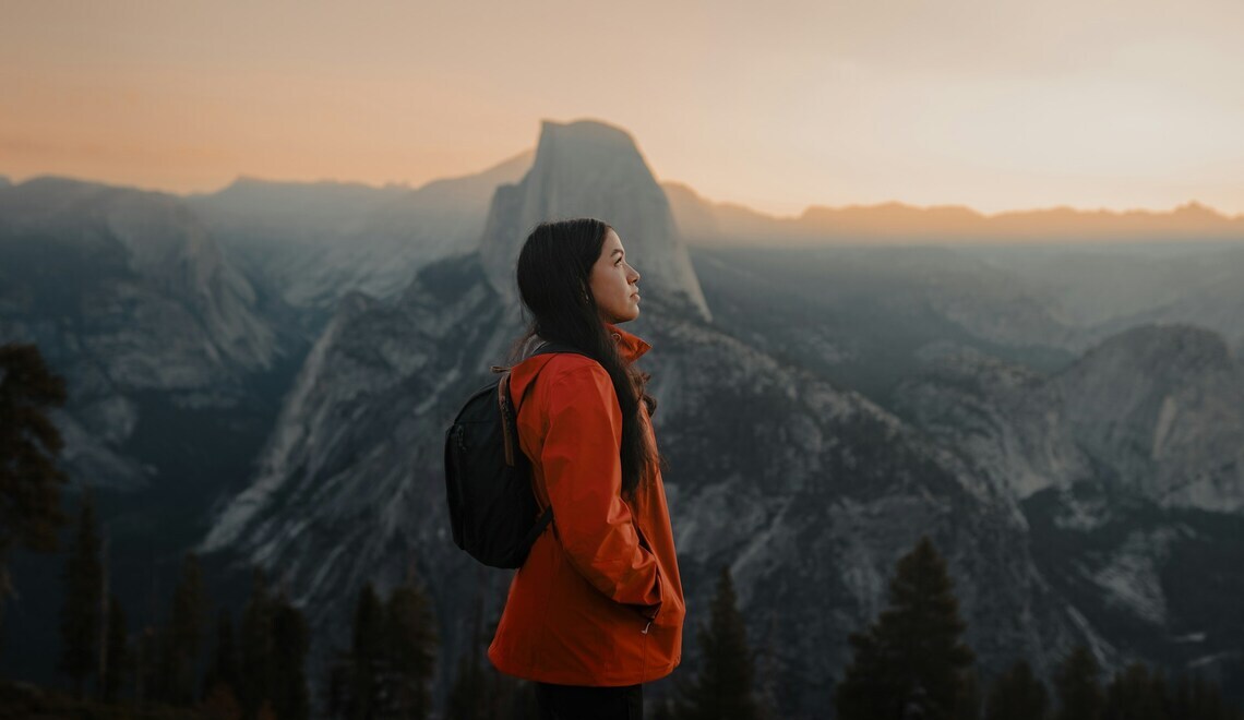 woman standing on the top of a mountain