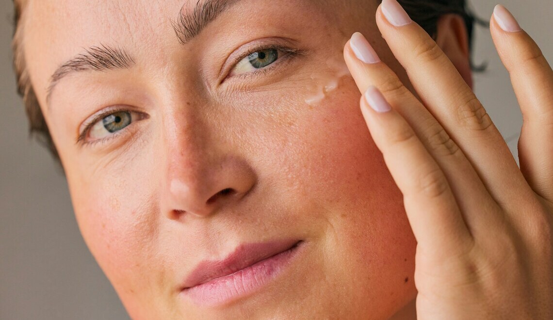 Close-up shot of a woman gently applying face serum