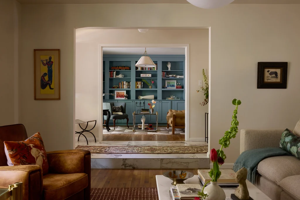 dusty blue library built ins and cognac leather chair in st louis stuyvesant home by steven miller folk mod interiors